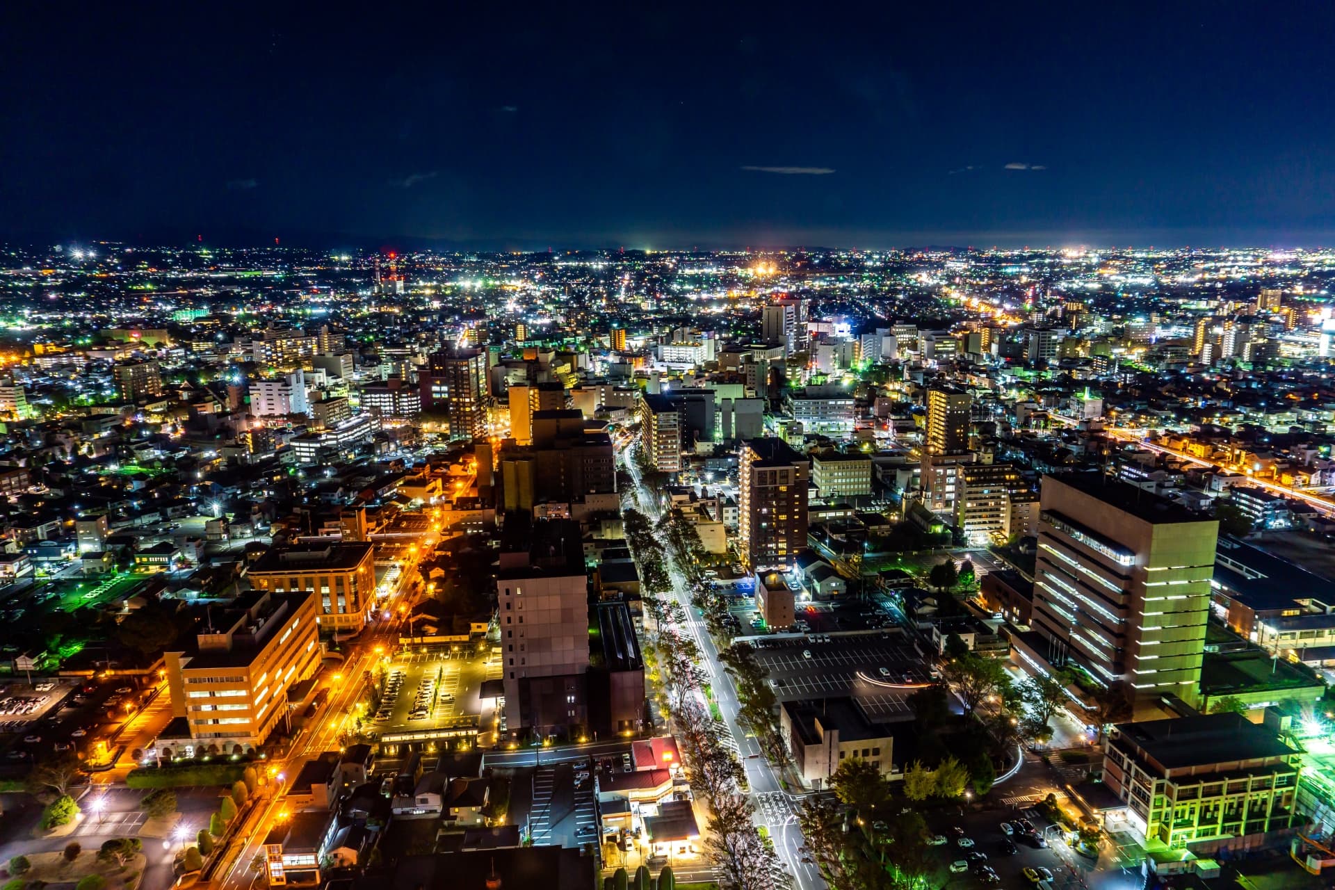 電気の灯りがともる市街地の夜景。電気設備の大切さを感じる風景。